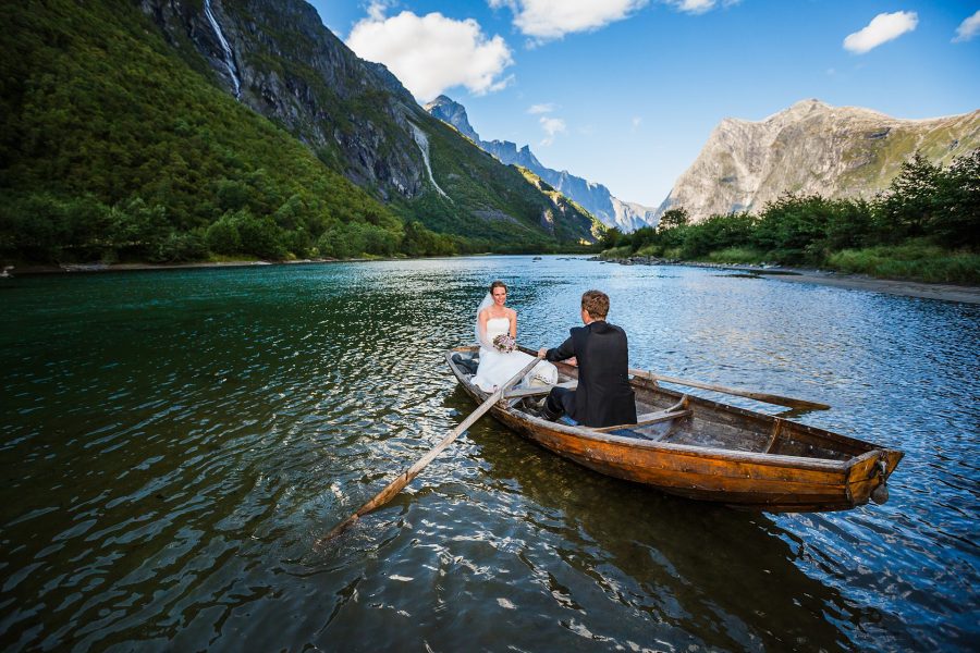 Brudepar ombord i båt ved Trollveggen i bakgrunnen